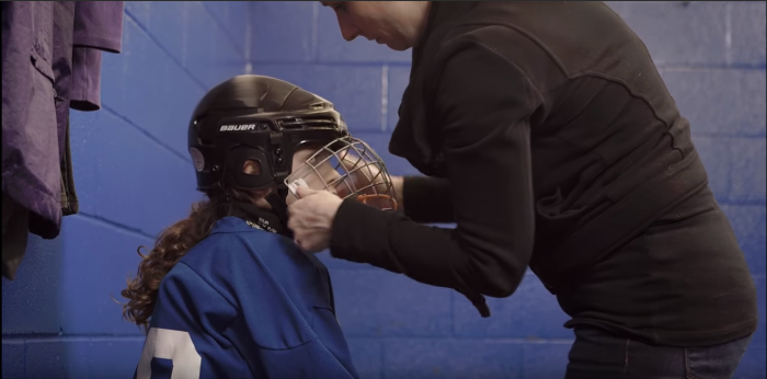 parent taking helmet off kid ice hockey | Source For Sports